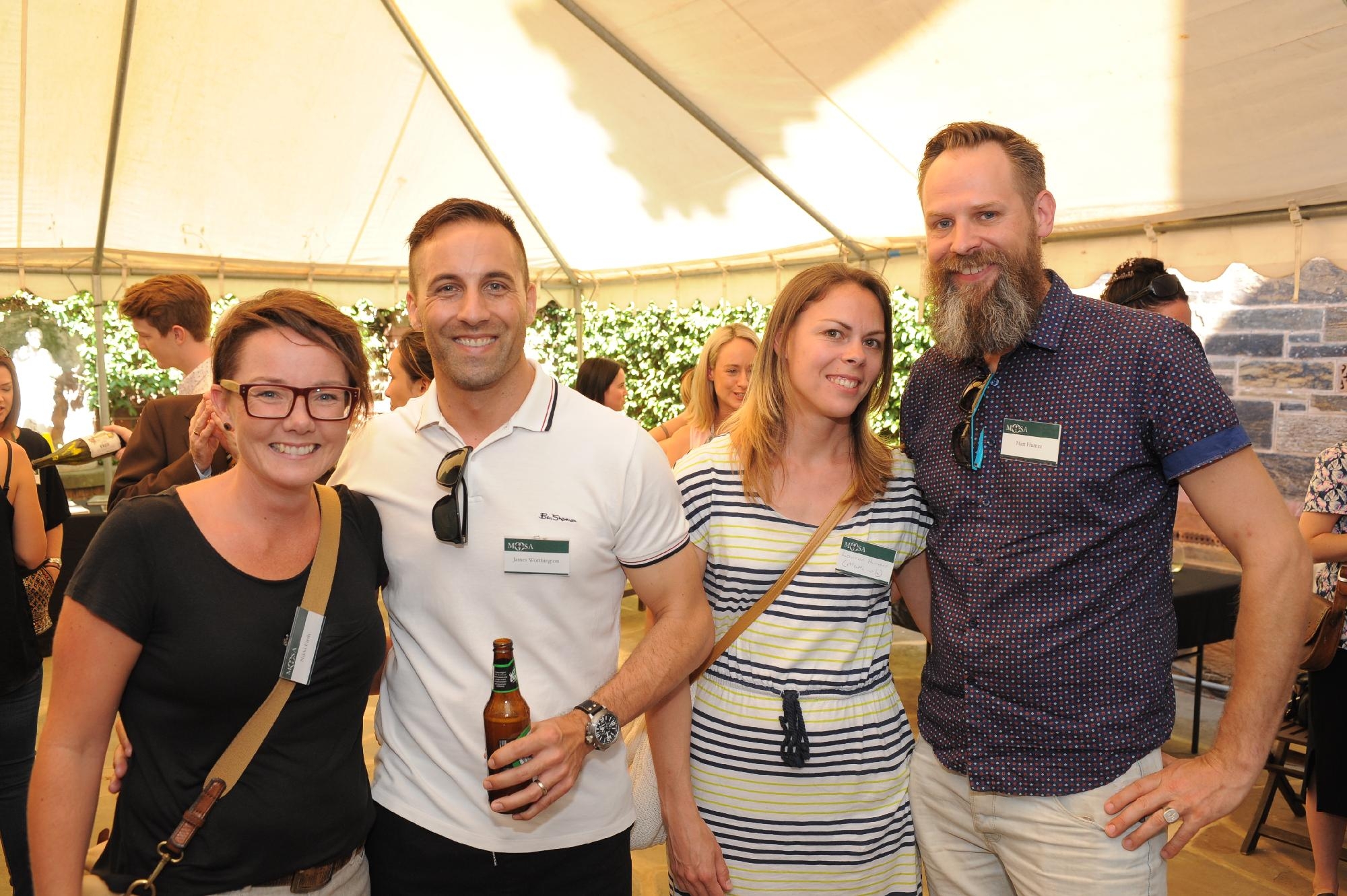 Mercedes College alumni smiling together at a MOSA reunion under a marquee.